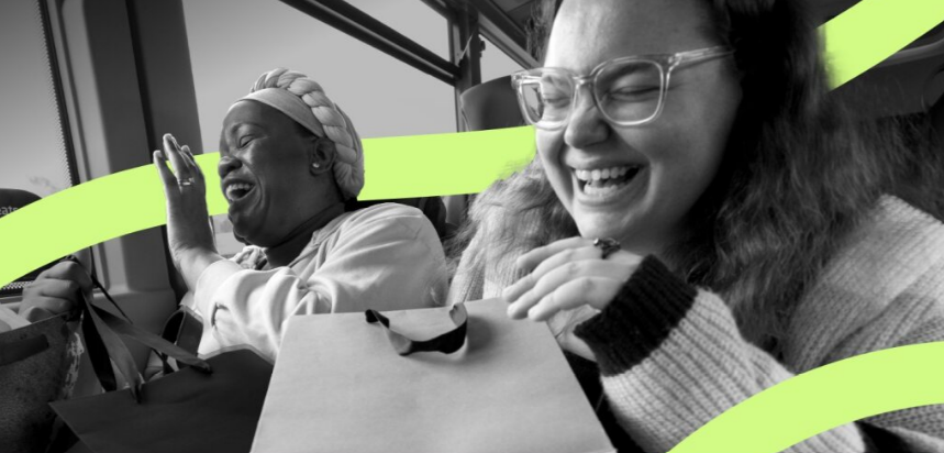 Two friends laughing on the bus