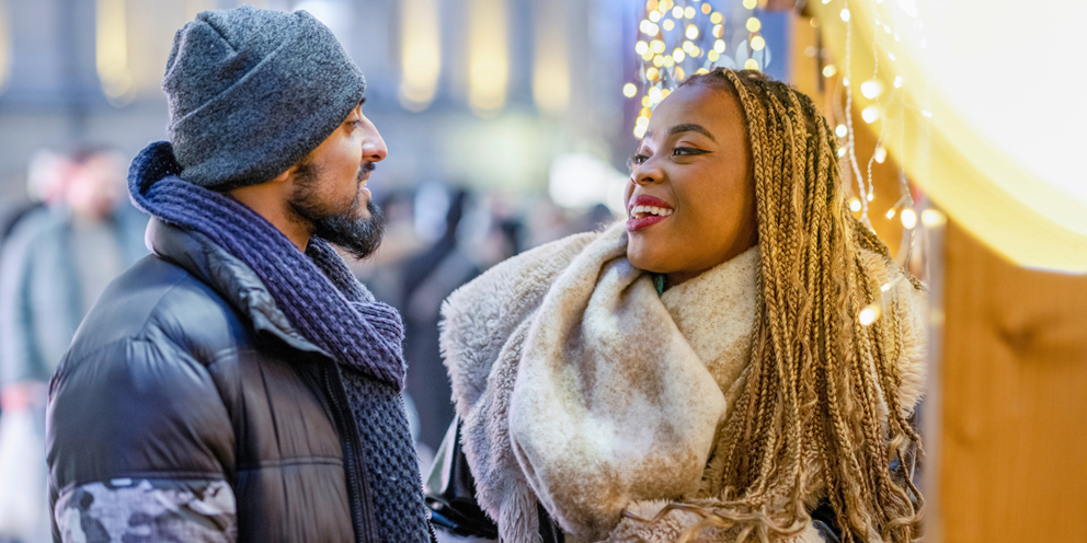 Two people looking happy at a Christmas market.